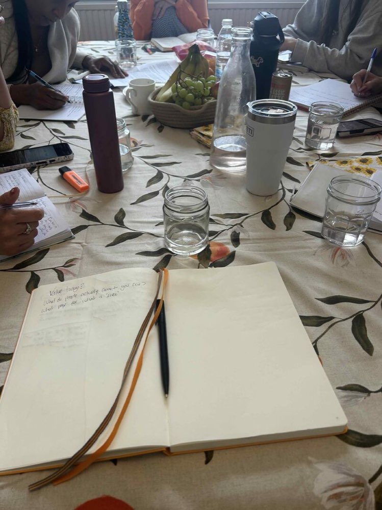 A Clarity Circle session: notebooks, pens and glasses of water around a table.